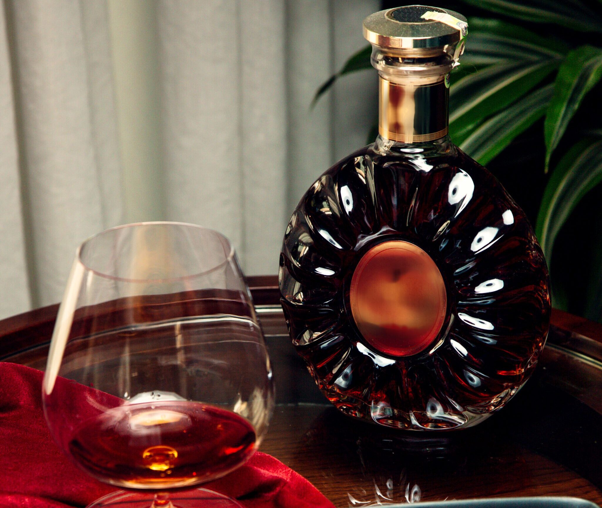 a glass and bottle of cognac and sigar